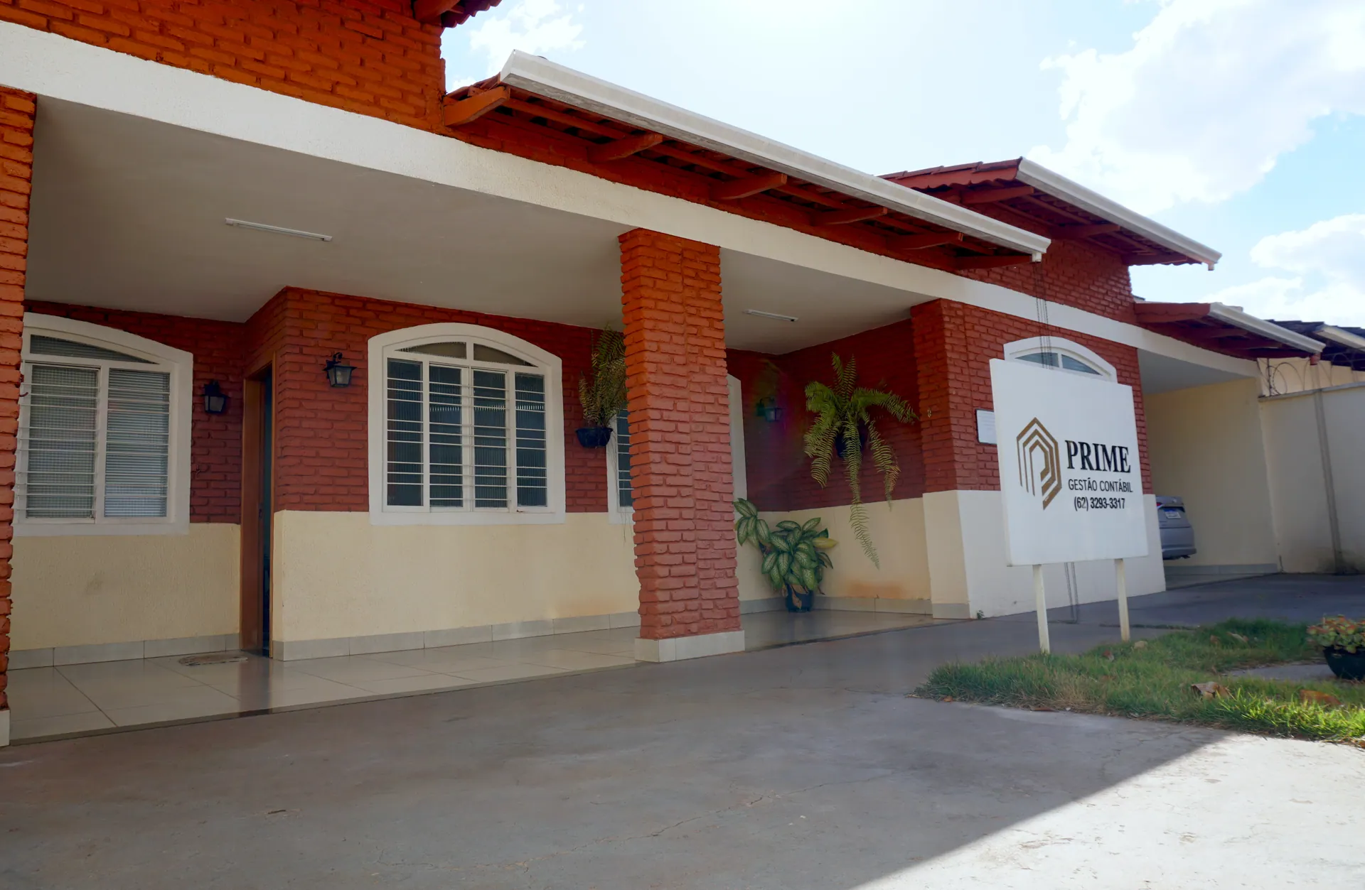 Equipe da Prime Gestão Contábil reunida em frente à fachada do escritório em Goiânia